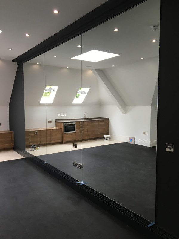 Frameless glass partition in loft conversion by Buckingham glaziers